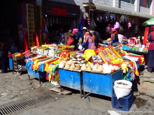 Market vendors with cheese and prayer flags